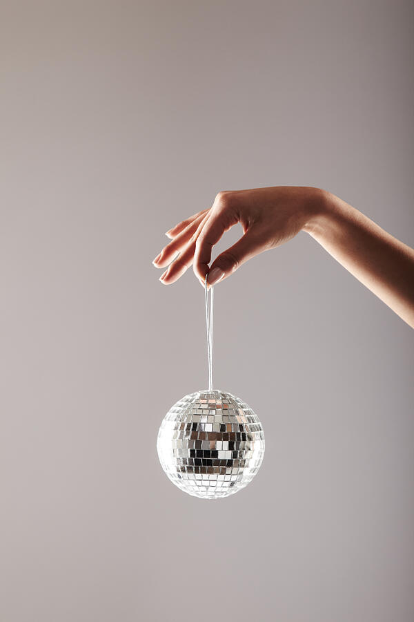 Womans Hand Holding a Disco Ball Photograph by GSPictures