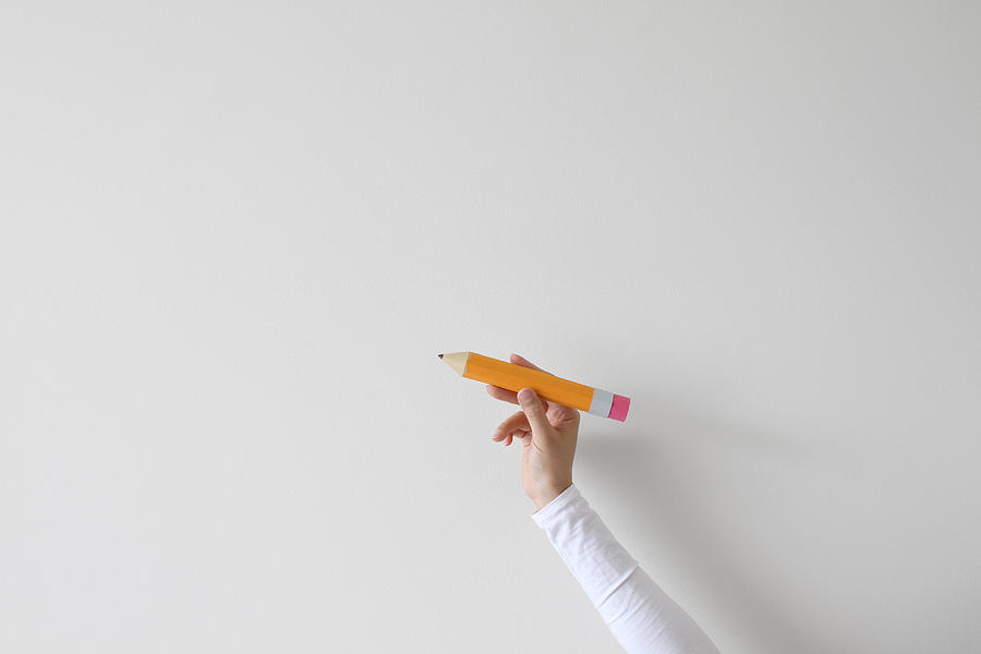 Womans hand holding an oversized pencil Photograph by Pchyburrs