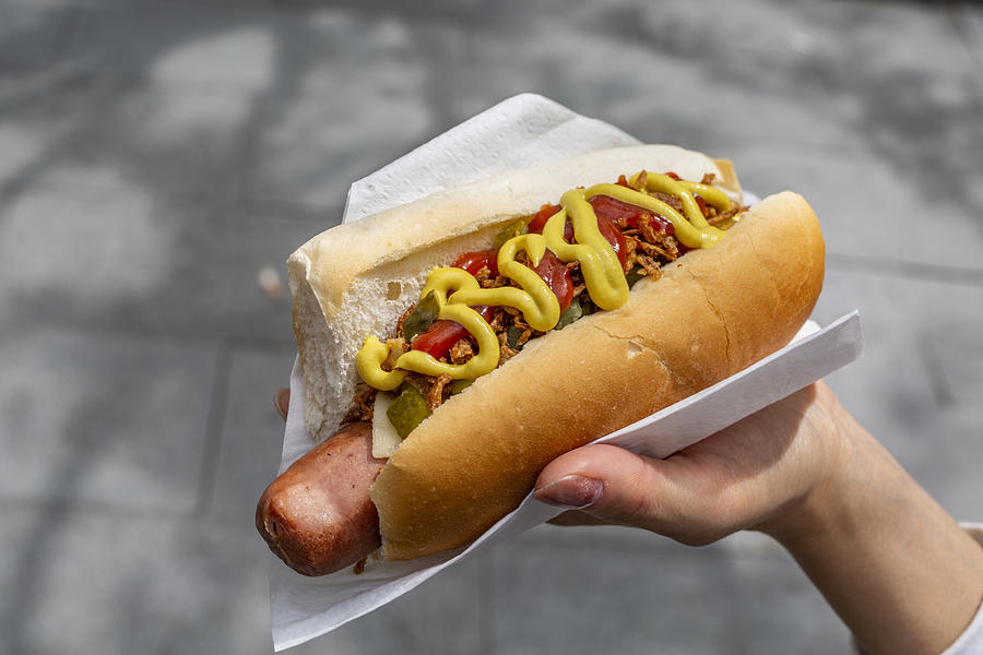 Womans Hand holding hot dog Photograph by Ivan