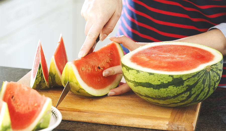 Womans hands cutting fresh watermelon Photograph by Anjelika Gretskaia