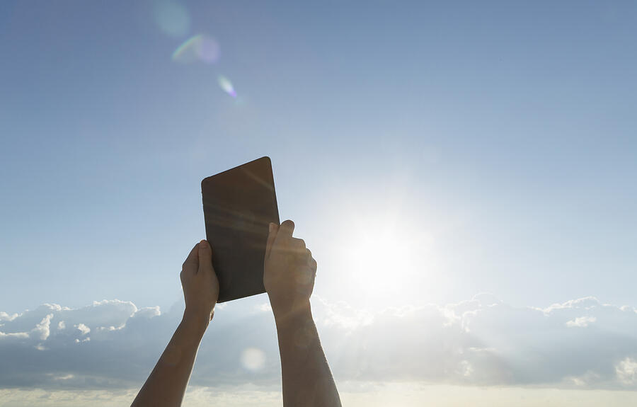 Womans hands pointing tablet to sun Photograph by Buena Vista Images
