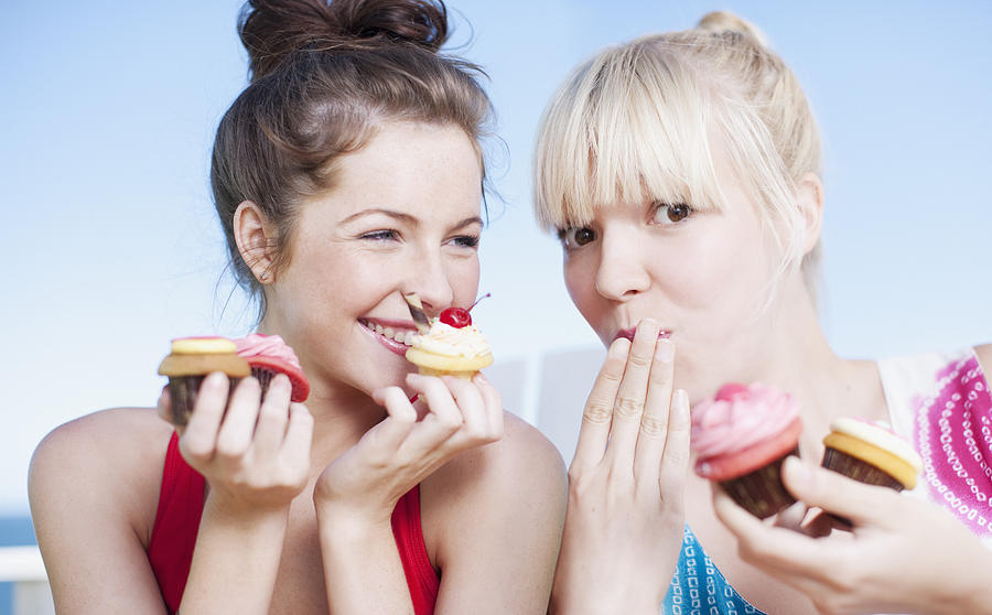 Women eating cupcakes Photograph by Tom Merton