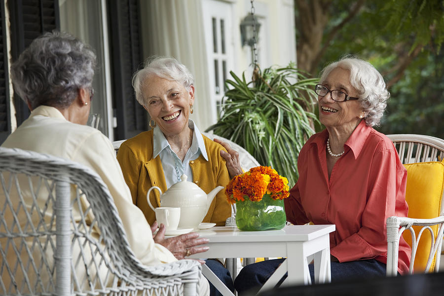 Women enjoying tea on porch Photograph by Ariel Skelley