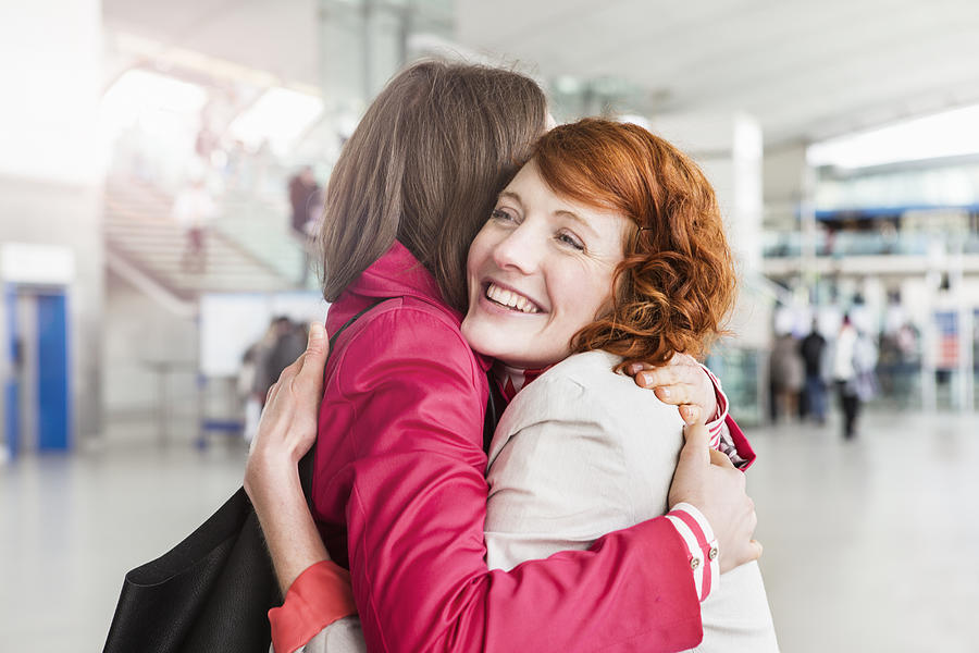 Women Greeting, Embracing, At Arrival Hall. Photograph by Betsie Van Der Meer