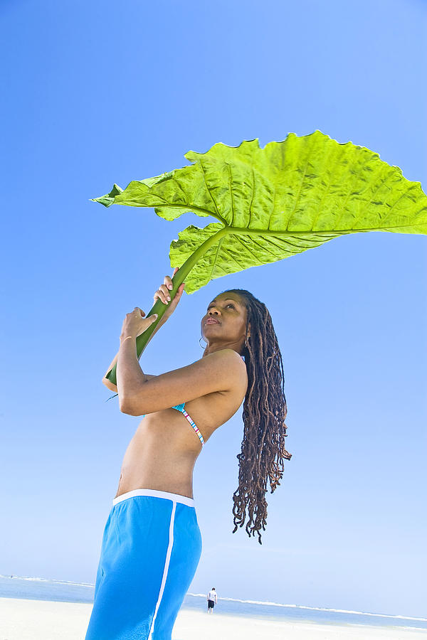 Women holds leaf for shade. Photograph by Jim Arbogast