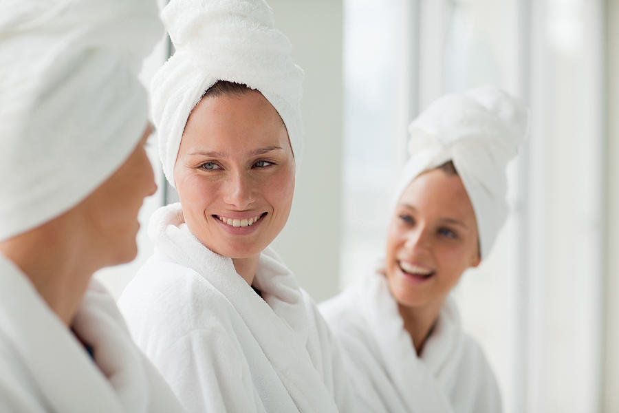 Women in bathrobes and hair wrapped in towels at spa Photograph by Martin Barraud