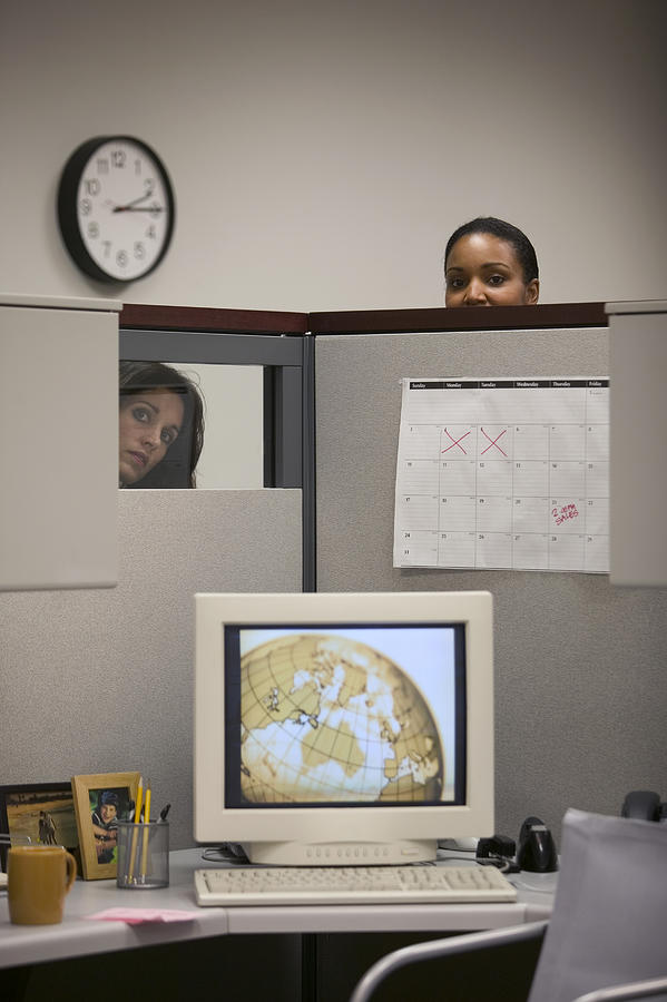 Women looking into cubicle Photograph by Comstock Images