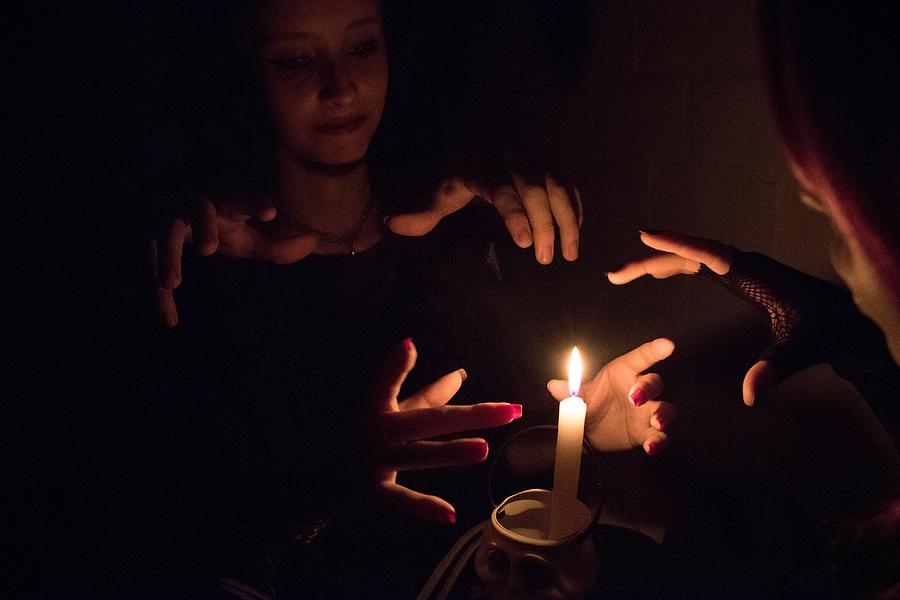 Women Practicing Witchcraft By Burning Candle In Darkroom Photograph by Vinicius Rafael / EyeEm