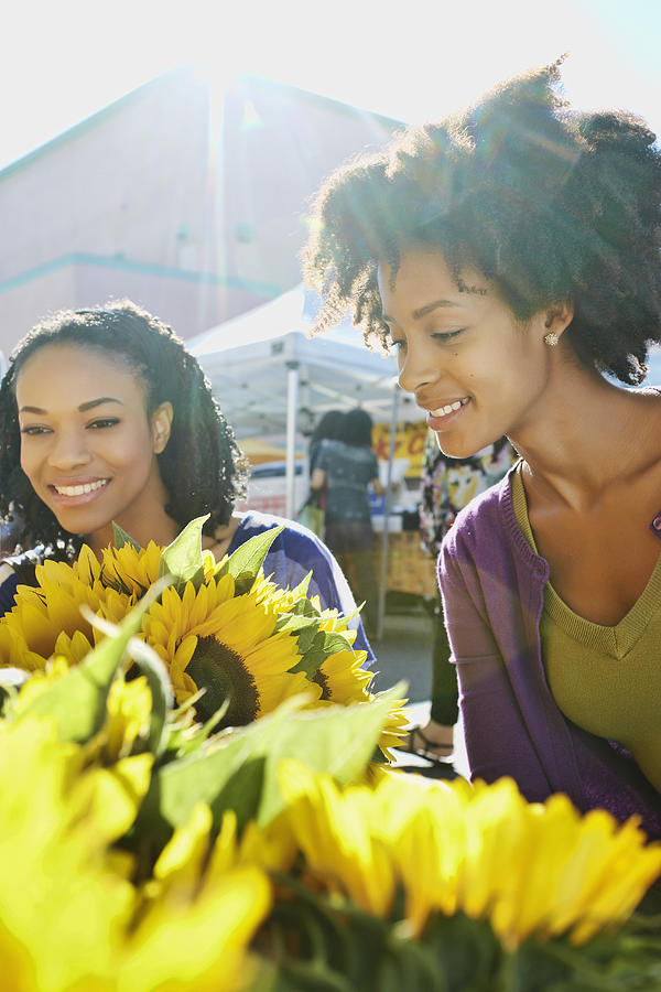 Women shopping together at flower stand Photograph by Peathegee Inc