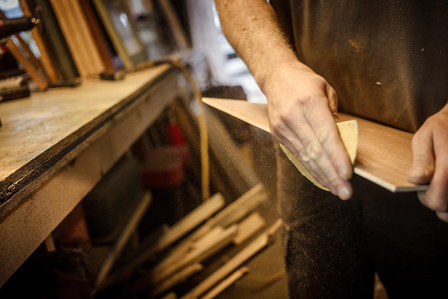 Wood artist in workshop, sanding wood, close-up Photograph by Heshphoto