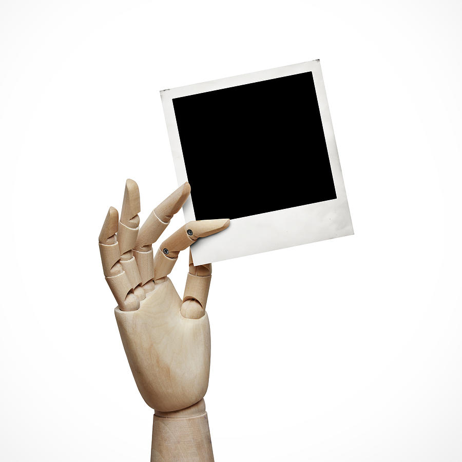 Wood hand with instant photo frame Photograph by Sfio Cracho