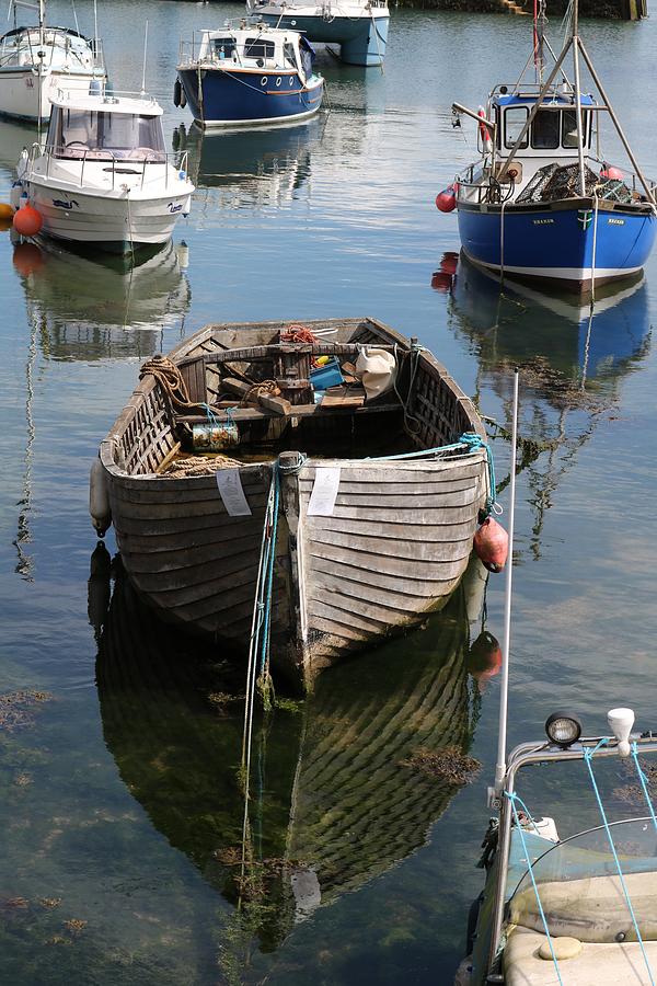 Small traditional boat reflecting in mirror like water Weekender