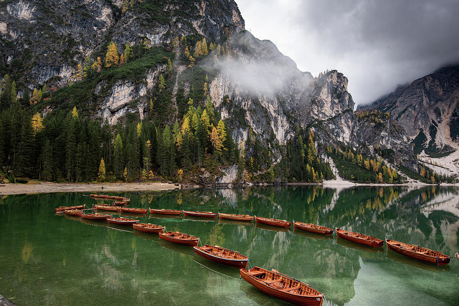 Wooden boats on the peaceful  lake. Lago di braies, Italy Photograph by Michalakis Ppalis