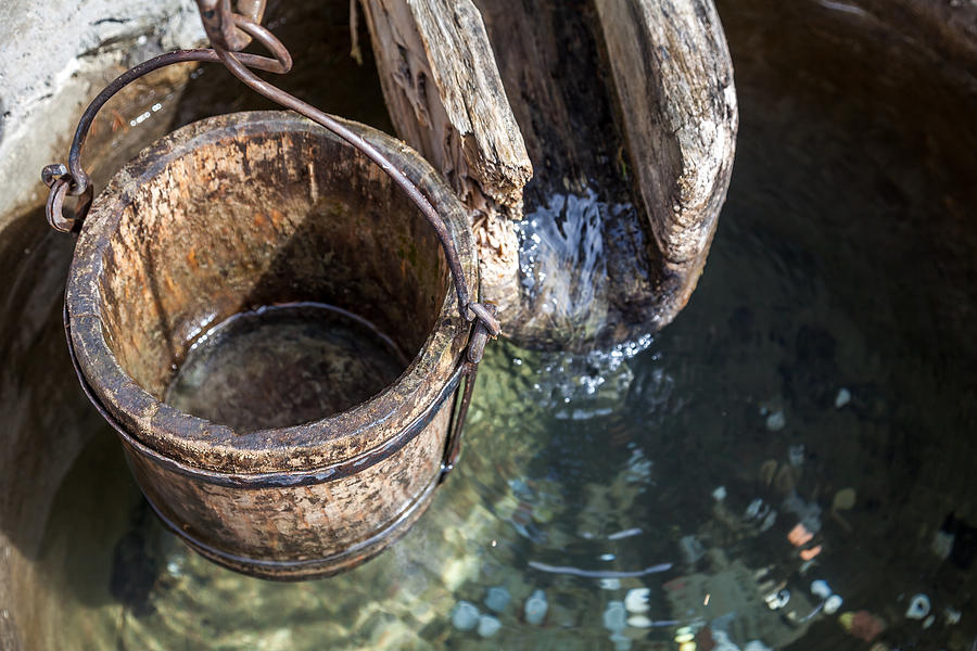 Wooden bucket and gutter on a well Photograph by © Santiago Urquijo