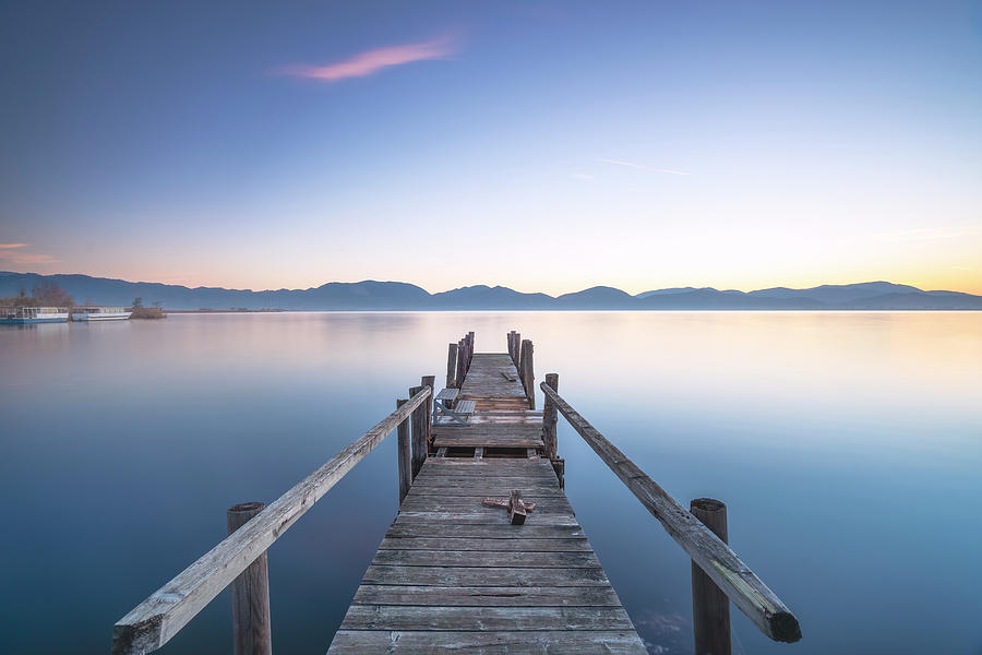 Wooden pier or jetty and lake at sunrise. Torre del lago Puccini ...
