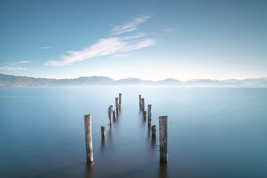 Wooden pier remains at sunrise. Lake Massaciuccoli Photograph by Stefano Orazzini
