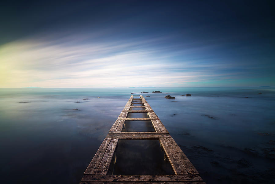 Wooden pier remains in a blue sea. Long Exposure. Photograph by Stefano Orazzini