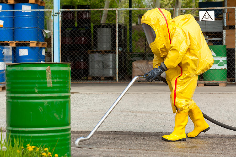 Worker in yellow hazmat suit cleaning ground Photograph by firemanYU