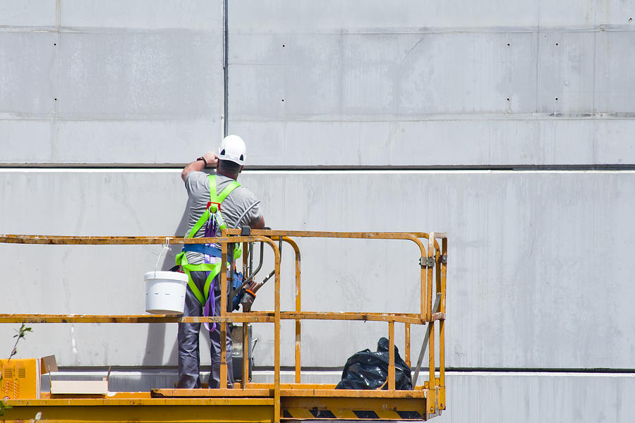 Worker painting on a cherry picker. Safety equipment Photograph by Mercedes Rancaño Otero
