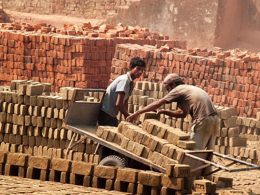 Workers carrying bricks at a brick factory in Bangladesh Photograph by Suc