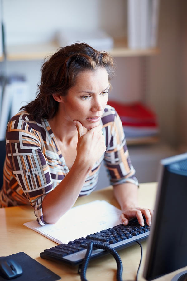 Worried businesswoman looking at computer screen Photograph by GlobalStock