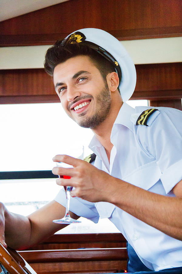 Yacht captain portrait drink in hand looking away Photograph by NicolasMcComber