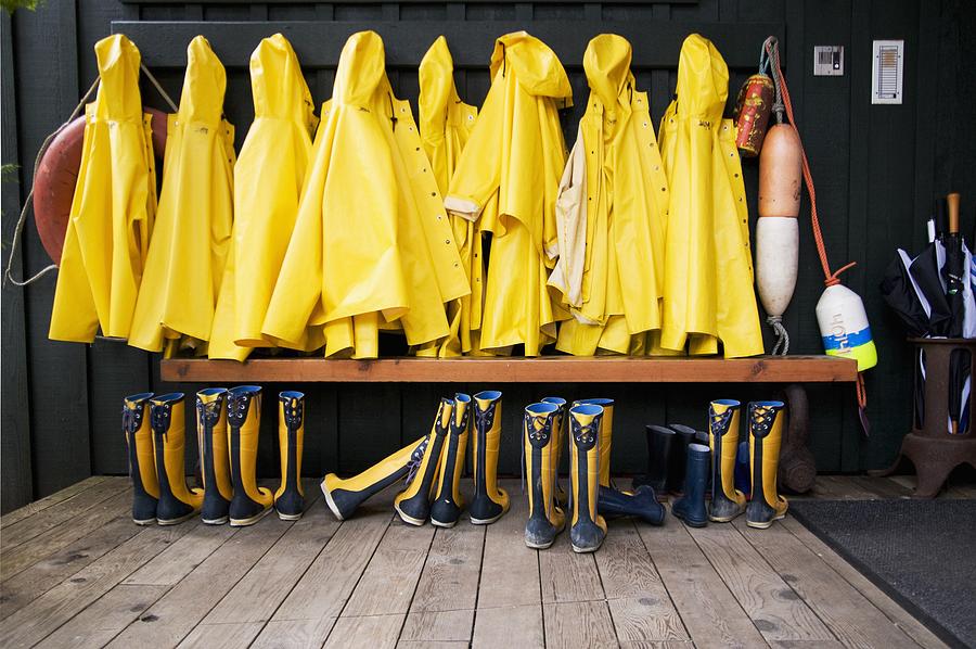 Yellow Raincoats And Rubber Boots Lined Up Photograph by Design Pics / Jeff Cruz