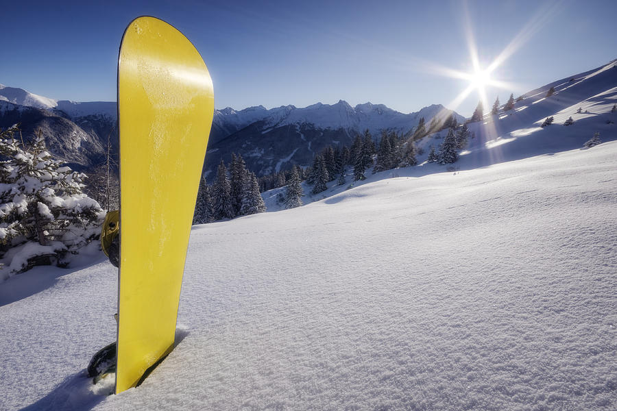 Yellow snowboard in snow on mountain Photograph by DaveLongMedia