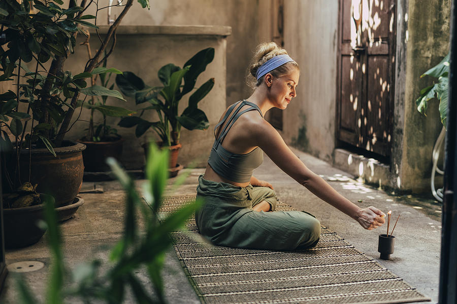 Yoga in the Garden: a Woman Doing Yoga While Enjoying the Scent of Natural Incense Sticks Photograph by FreshSplash