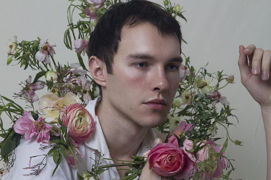 Young adult male  surrounded by flowers Photograph by Rachel Thalia Fisher