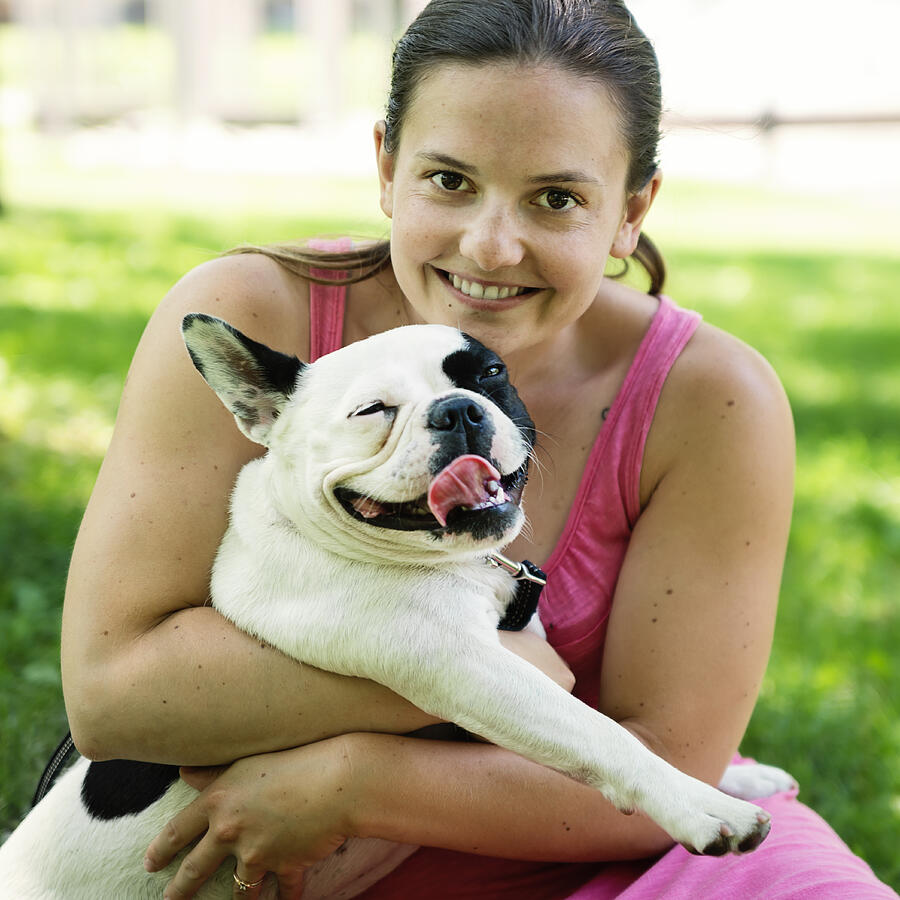 Young adult woman in a park with a french bulldog Photograph by Martinedoucet