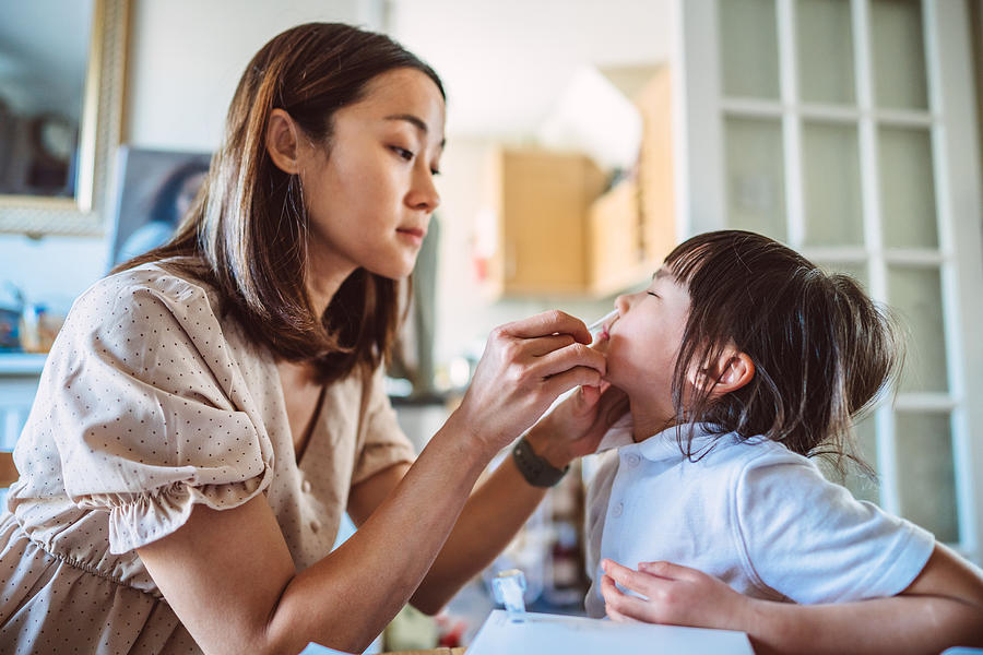 Young Asian mom carrying out a Covid-19 self test for her daughter at home Photograph by Images By Tang Ming Tung Young Asian mom carrying out a Covid-19 self test for her daughter at home Photograph by Images By Tang Ming Tung