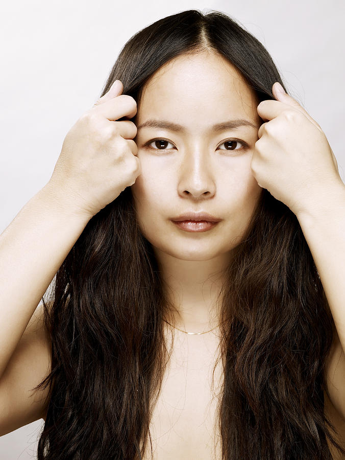Young Asian Woman Holding Hair Back From Her Face Photograph by Ballyscanlon