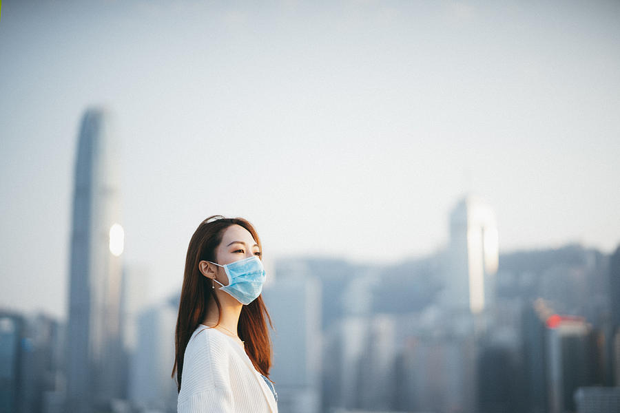 Young Asian woman wearing a protective face mask to prevent the spread of coronavirus, a global health emergency over outbreak Photograph by AsiaVision