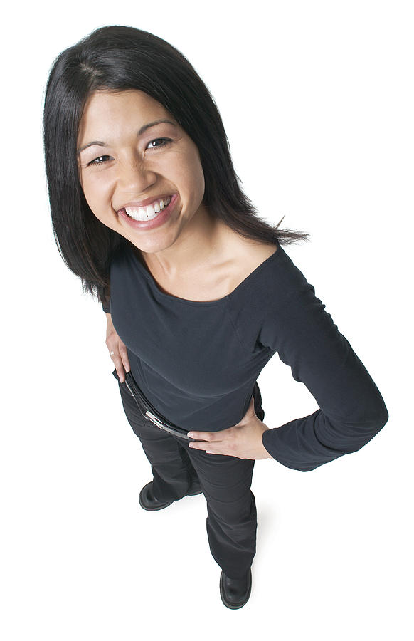 Young Attractive Asian Woman Dressed In Black Puts Her Hands On Her Hips And Smiles Up To The Camera Photograph by Photodisc