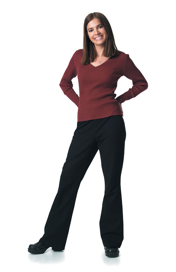 Young Attractive Caucasian Woman In Black Pants And Red Sweater Puts Her Hand On Her Hips Smiles Photograph by Photodisc