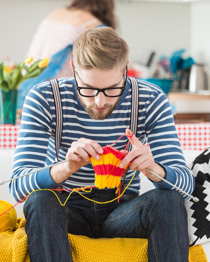 Young bearded man knitting Photograph by Izusek