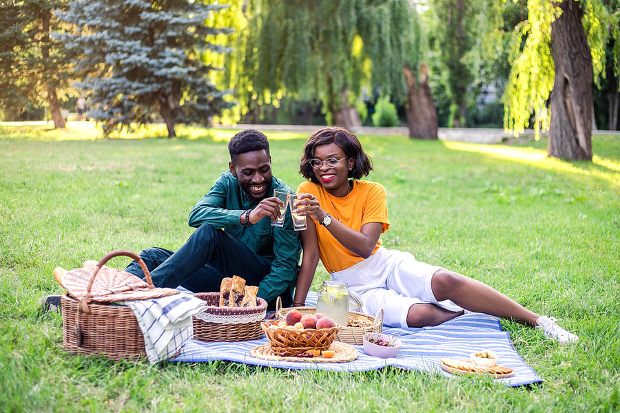 Young black couple on picnic in the park. Photograph by Evgeniia Siiankovskaia