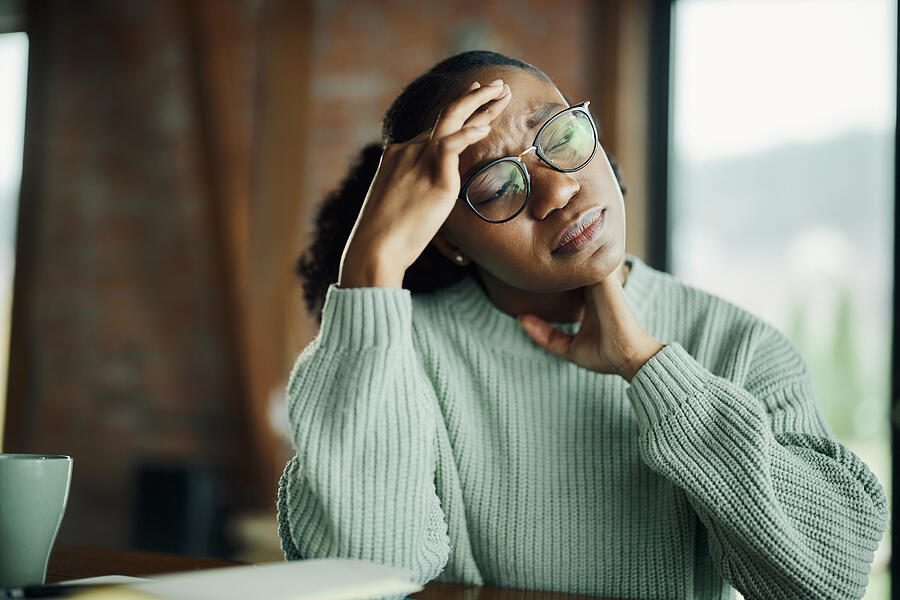 Young black woman having a headache at home. Photograph by Skynesher Young black woman having a headache at home. Photograph by Skynesher