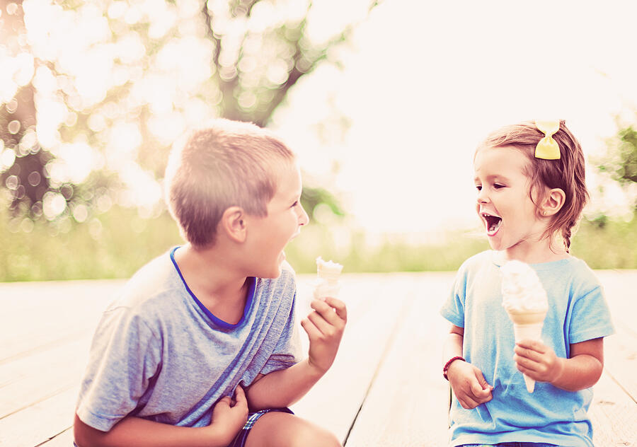 Young boy and girl enjoying ice cream on a summer day Photograph by Vitapix