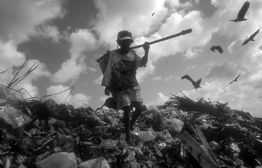 Young Boy Climbing and Picking Through Landfill Photograph by Brasil2