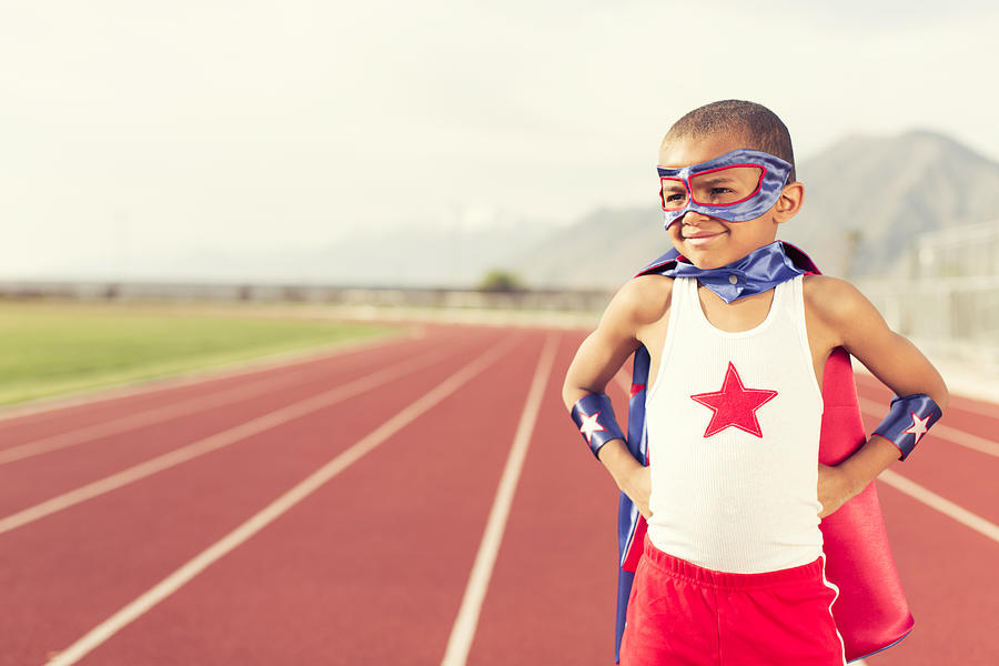 Young Boy Dressed as Superhero Stands on Running Track Photograph by RichVintage