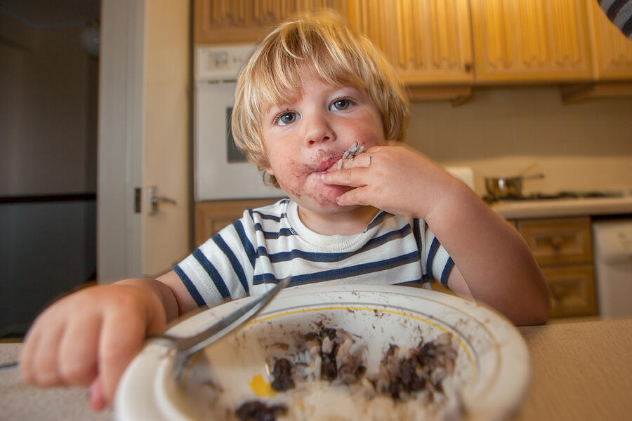 Young boy eating with a spoon Photograph by Paul Mansfield Photography