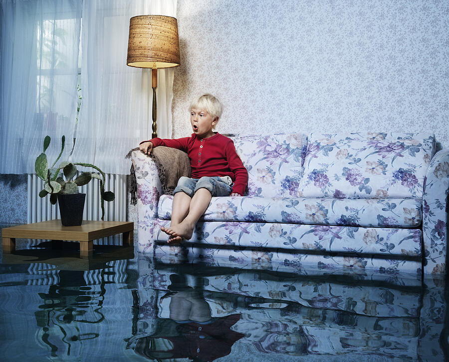 Young Boy In Sofa In Flooded Room Photograph by Henrik Sorensen