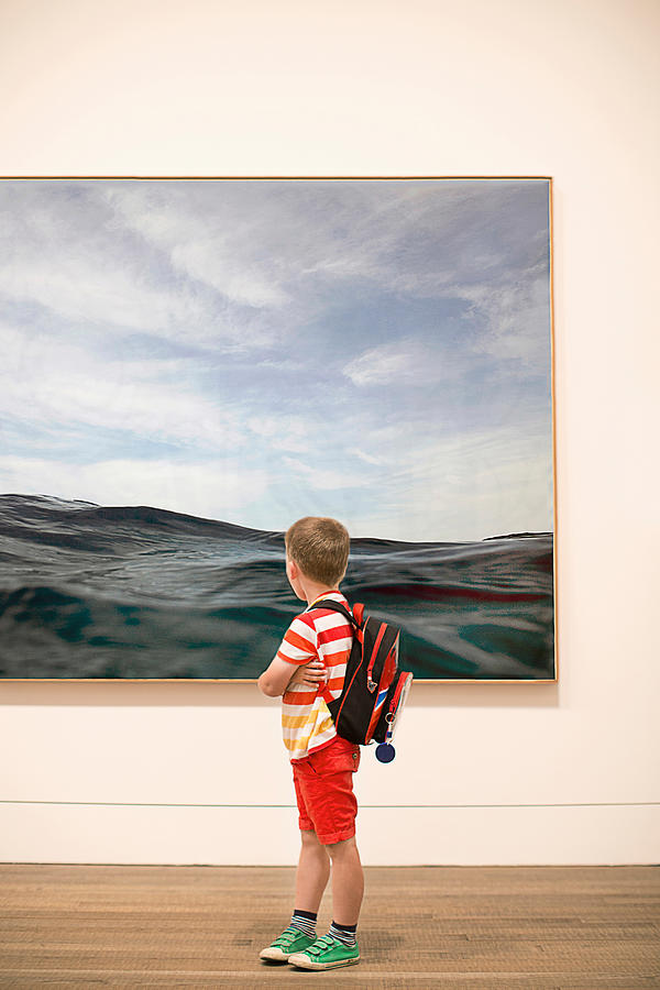 Young boy looking at picture in gallery Photograph by Gary John Norman