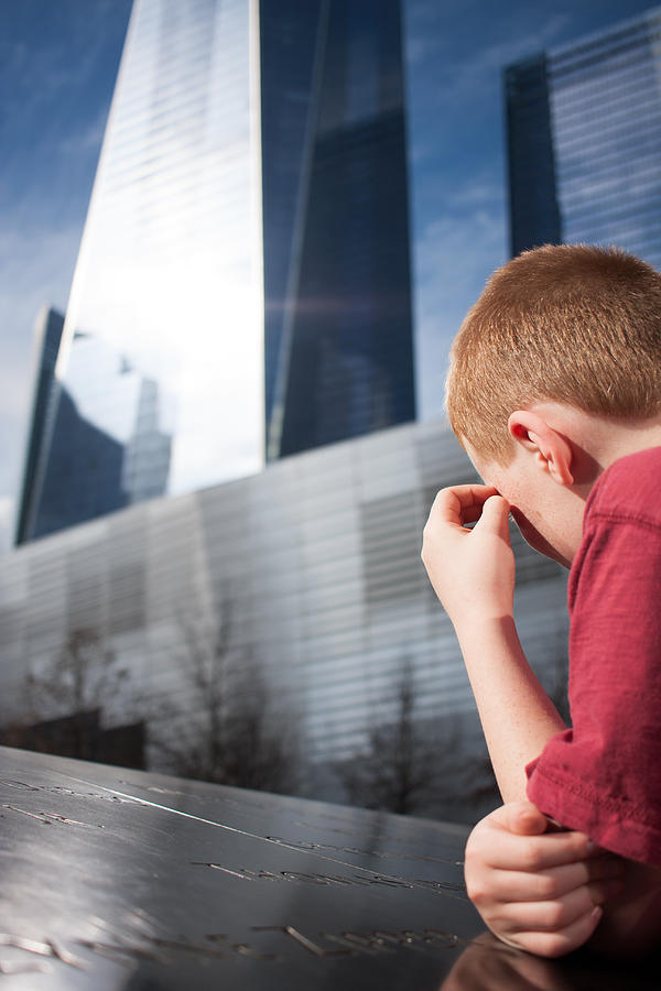Young boy looking at the names engraved on the WTC Memorial trying to comprehend the magnitude of what he is seeing Photograph by Michael Godek