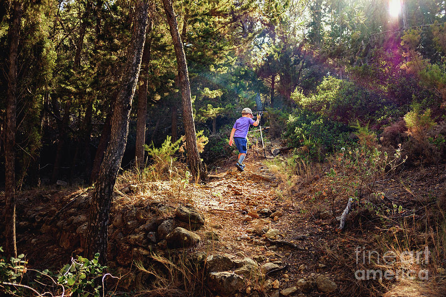 Young boy on his back walks through the forest exercising to relax and explore nature. Photograph by Joaquin Corbalan