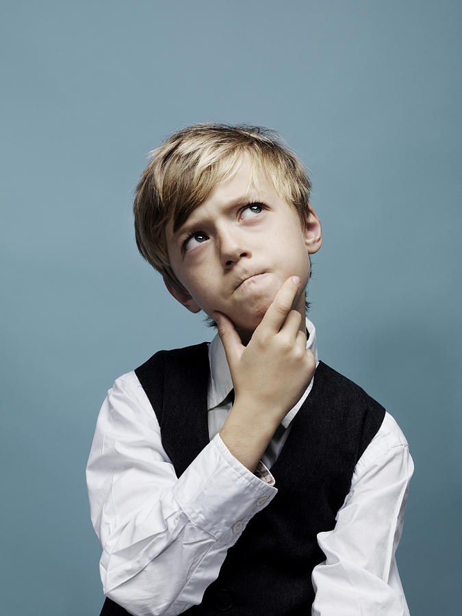 Young boy pondering with hand on chin Photograph by Henrik Sorensen