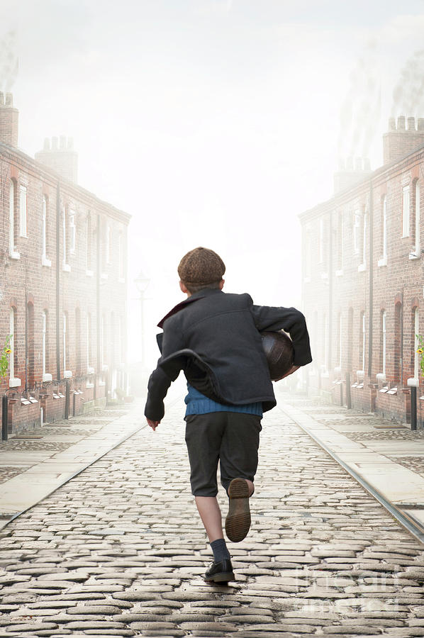 Young Boy Running On A Cobbled Street Carrying A Vintage Footbal Photograph by Lee Avison