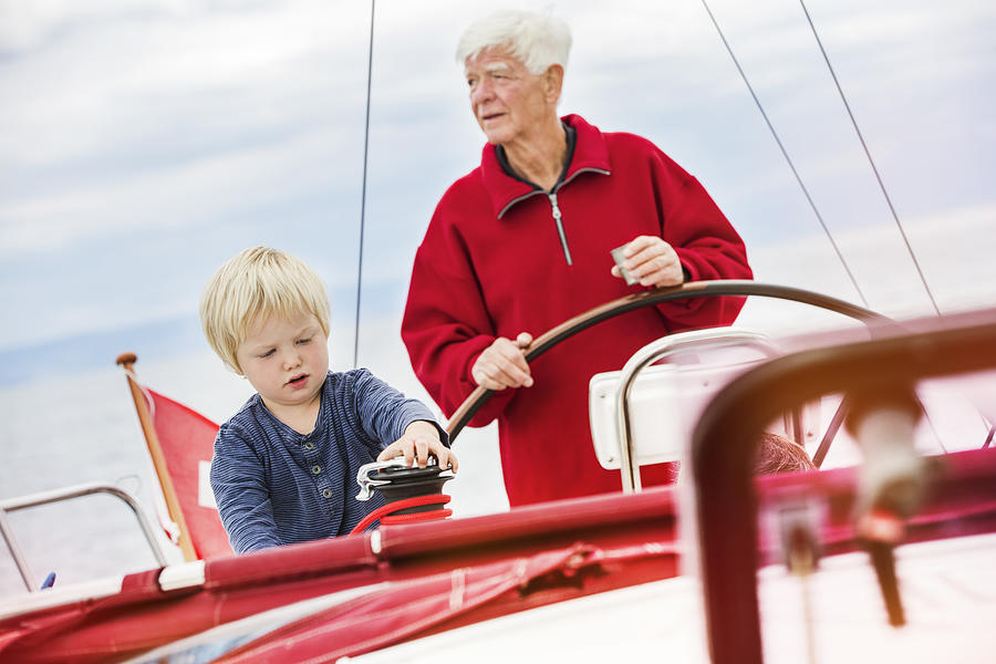 Young boy with great grandfather on sailing boat, Geneva, Switzerland, Europe Photograph by Igor Emmerich